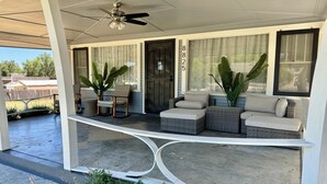 A covered porch with wicker furniture, a ceiling fan, and large windows. - Historic Atascadero Colony Charmer! (Atascadero)