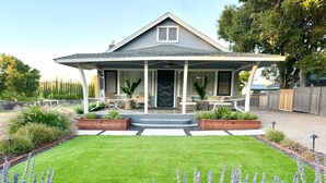 A house with a covered porch, a well-maintained lawn, and a garden with lavender plants. - Historic Atascadero Colony Charmer! (Atascadero)