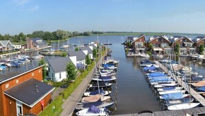A marina with boats docked along a narrow waterway, surrounded by residential buildings.