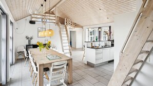 Una cocina amplia con una isla central, vigas de madera en el techo y un lavaplatos empotrado.