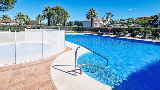 A clear blue swimming pool with a tiled deck, lounge chairs, and a lifeguard stand. - Arcos Gardens Golf by Interhome (Arcos de la Frontera)