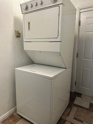 Máquina de lavar e secar frontal com botões de controle e cabo de alimentação conectado.