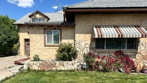 Una casa con fachada de piedra, techo inclinado y un pequeño porche.