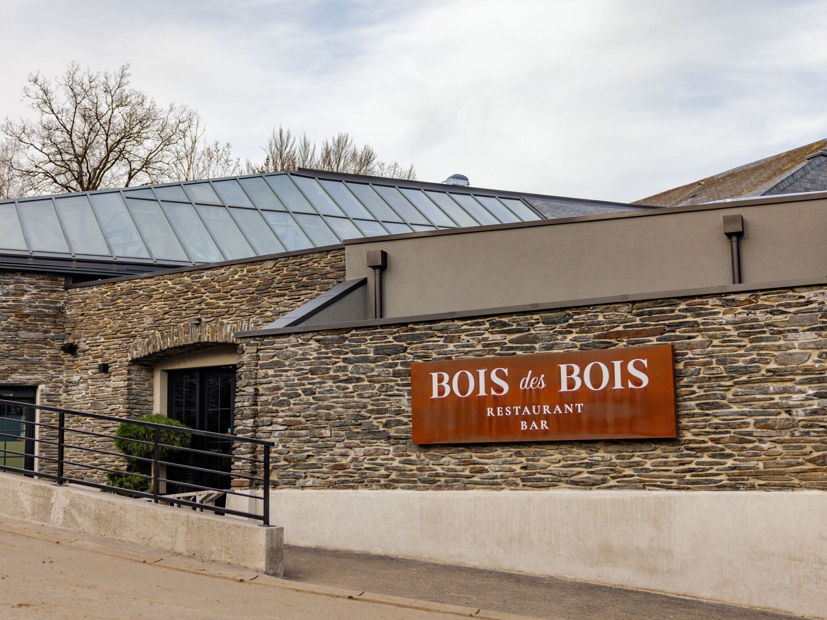 A restaurant named Bois des Bois with a stone facade and a metal roof.