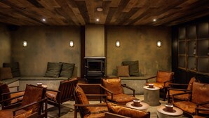 Un salon confortable avec des fauteuils en cuir, un canapé et une cheminée.