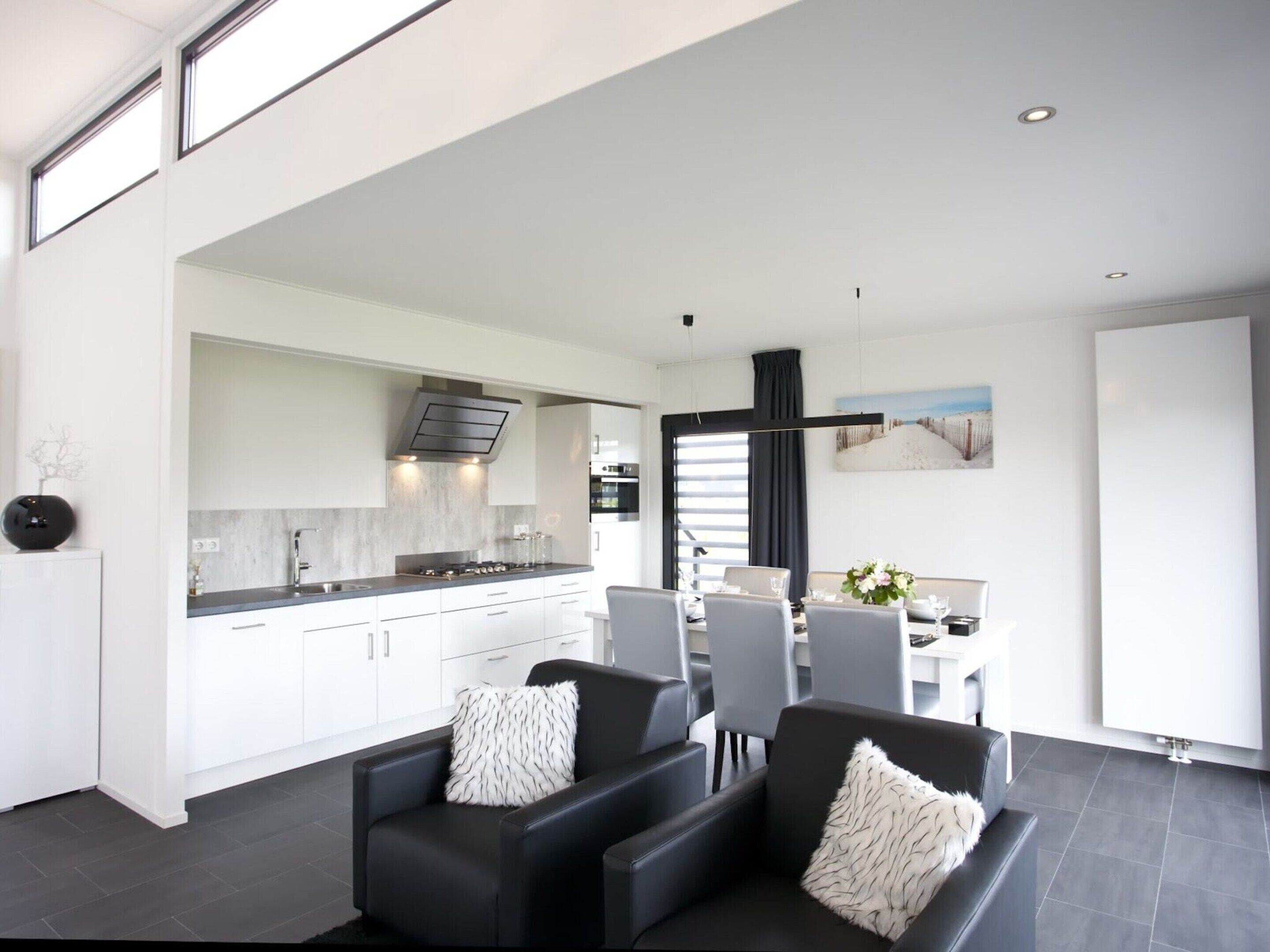 A modern living space with a kitchen, dining area, and seating.