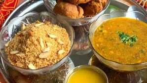 Een traditionele Indiase maaltijd met naanbrood, een linzencurry, een rijstgerecht en een portie yoghurt.