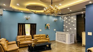 A living room with a blue wall, a chandelier, a sofa, and a coffee table.