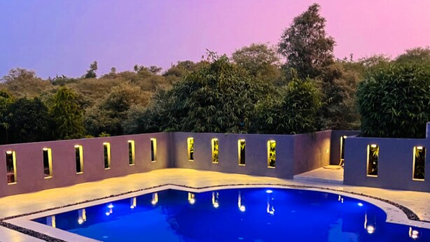 A rectangular swimming pool with a surrounding deck, surrounded by a low wall with evenly spaced windows.