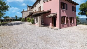 A two-story building with a gravel driveway and a pink facade.
