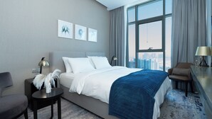 Ein modernes Hotelzimmer mit einem großen Bett, einem kleinen Nachttisch, einem Sessel und Blick auf die Stadt durch große Fenster.