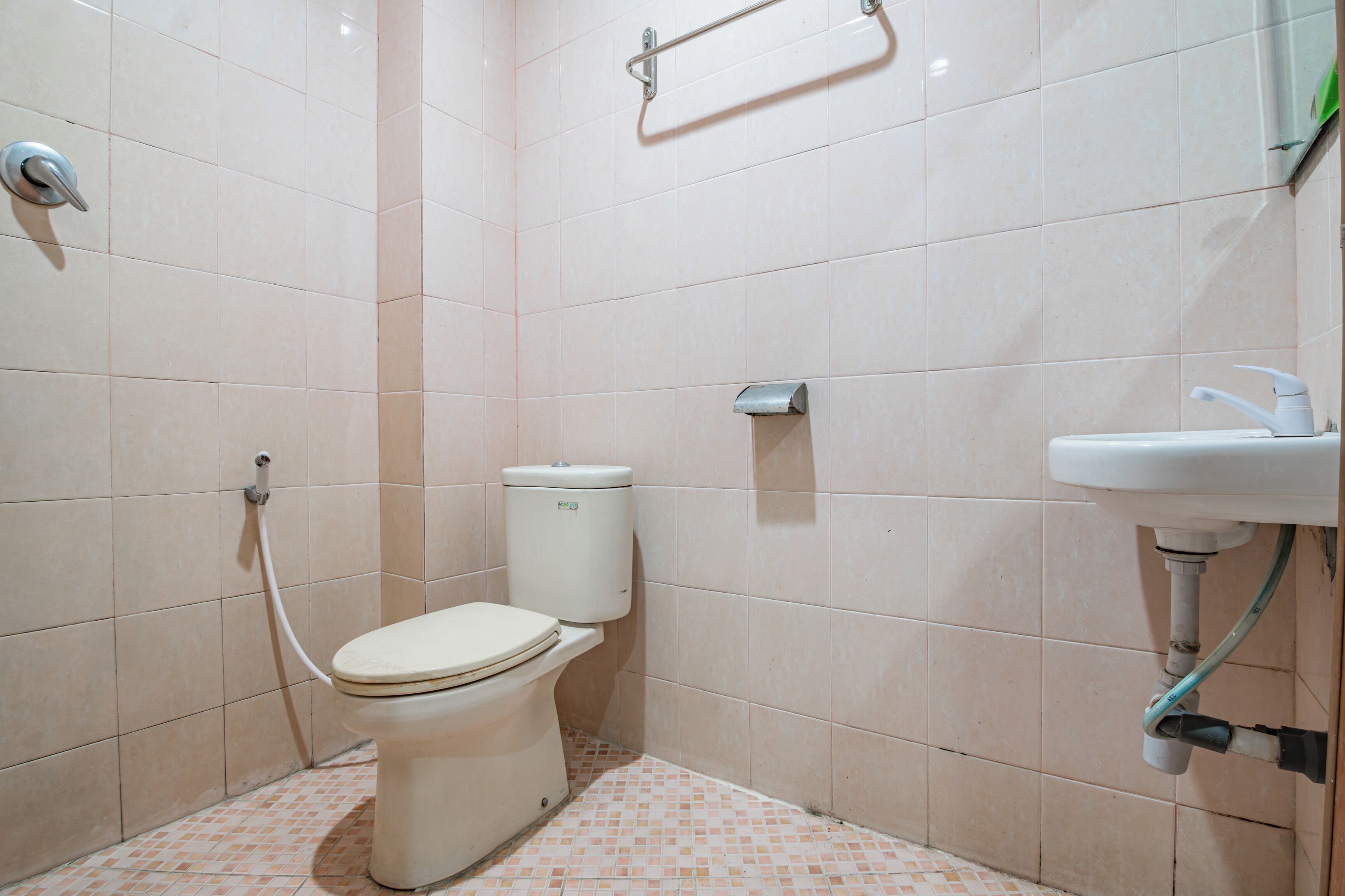 A small bathroom with a toilet, a sink, and a hand dryer.