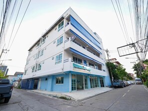 A multi-story building with a sign reading "RoomQuest North Patuxent". - RQ North Pattaya By Collection O (Pattaya)