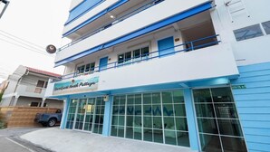 Un edificio de varios pisos con un cartel que dice 'RoomGuest North Pattaya'.