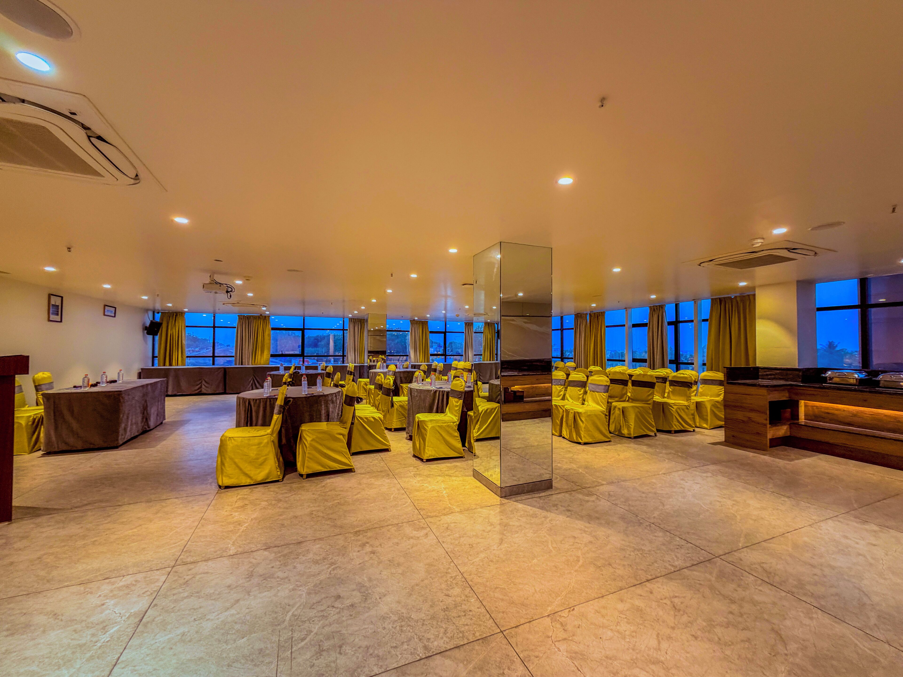 A spacious conference room with high ceilings, large windows, and a modern design.
