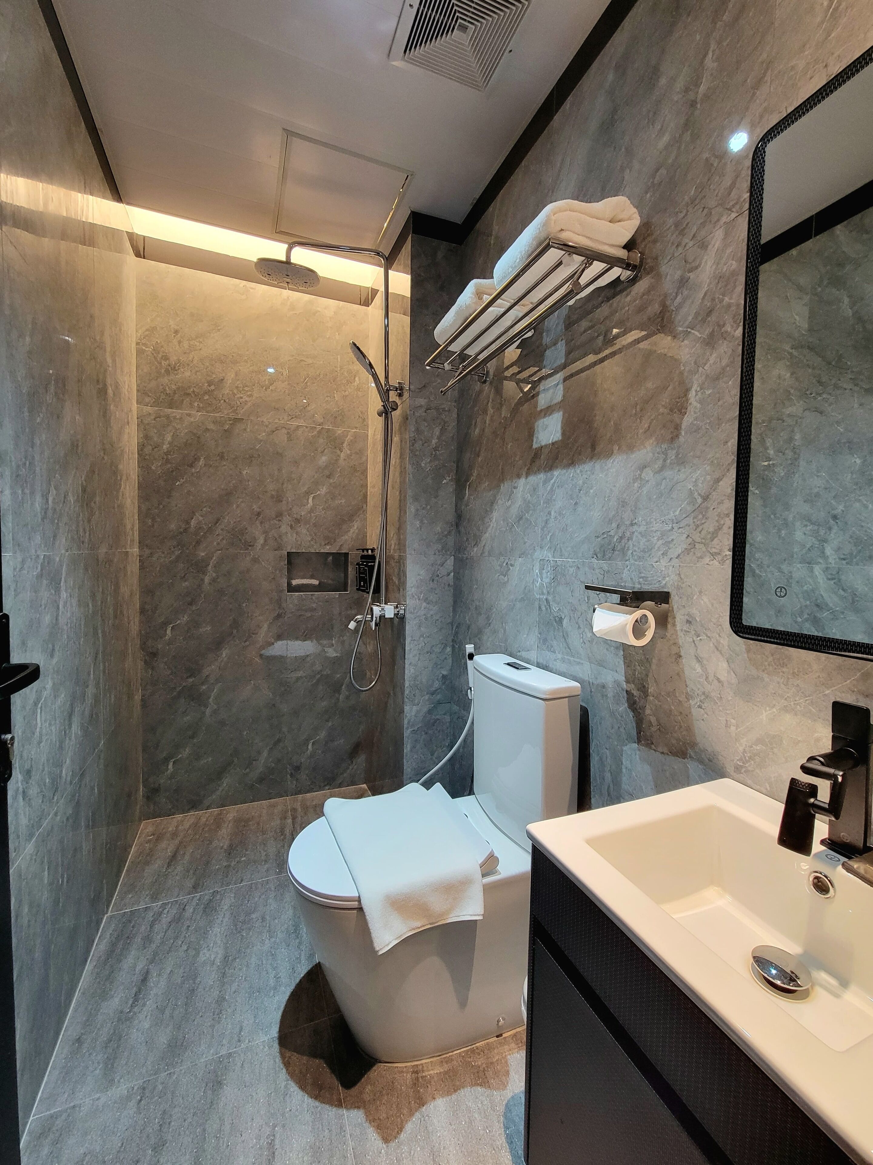 Un baño moderno con ducha, inodoro y lavamanos.