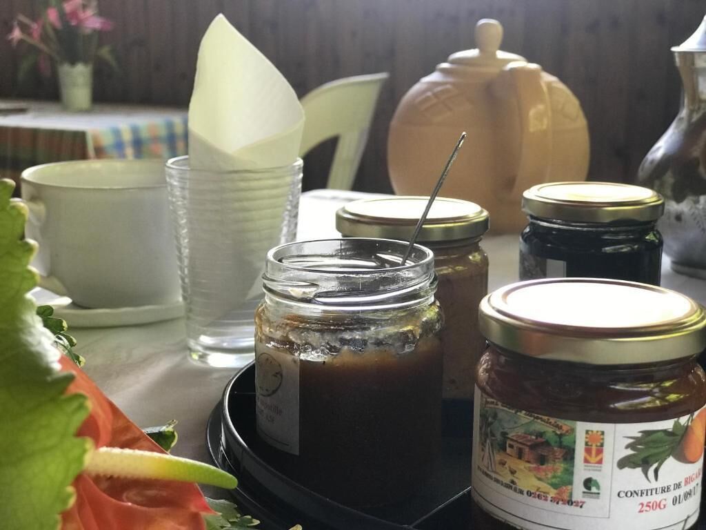 A table with jars of preserves, a teapot, and a tray.