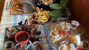 Une table où sont présentés divers aliments, notamment des pâtisseries, des fruits et des condiments.