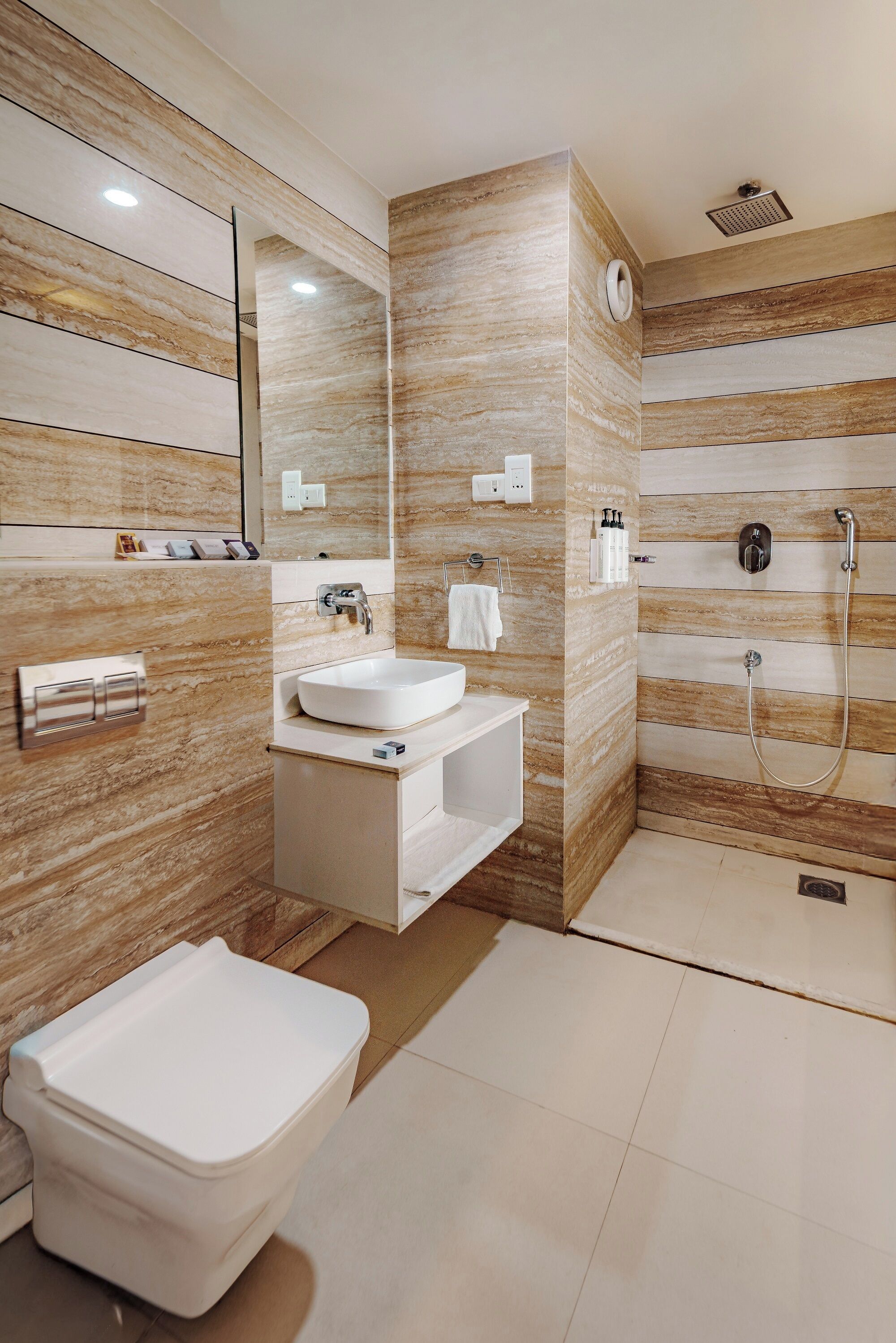 Une salle de bain moderne avec un lavabo blanc, des toilettes et un espace douche.
