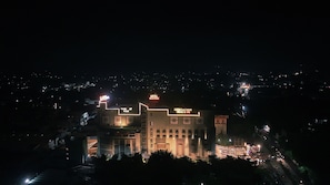 A multi-story building with illuminated signage for 'Hotel HighRise' and 'Gursikha & Ld Mark Cinemas & Gym.'
