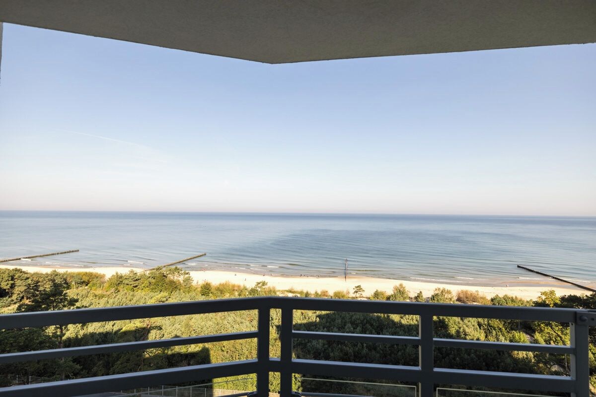 A balcony with a view of a beach and ocean.