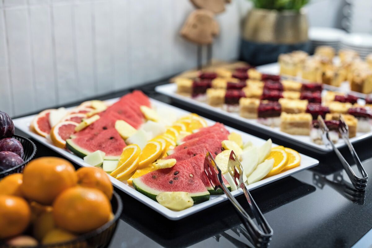 En buffet med forskelligt frugt og desserter.