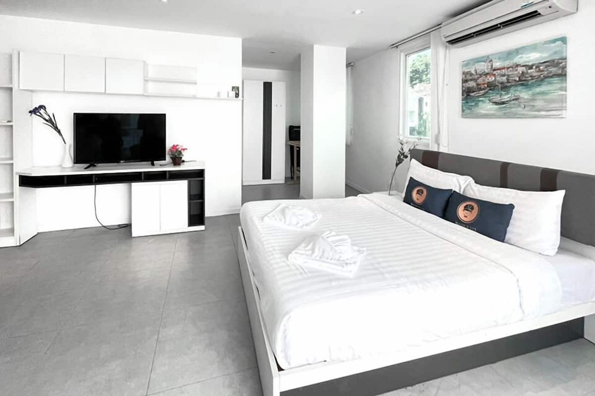 Une chambre d’hôtel moderne avec un grand lit, une télévision et un tableau au mur.