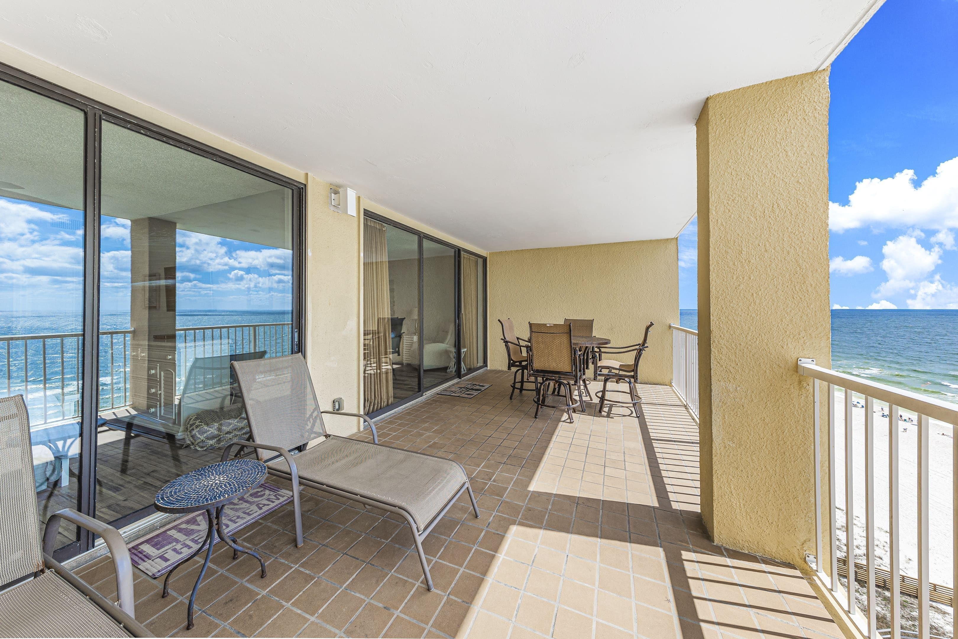 Ein Balkon mit Blick auf das Meer, ausgestattet mit Stühlen und einem Tisch.