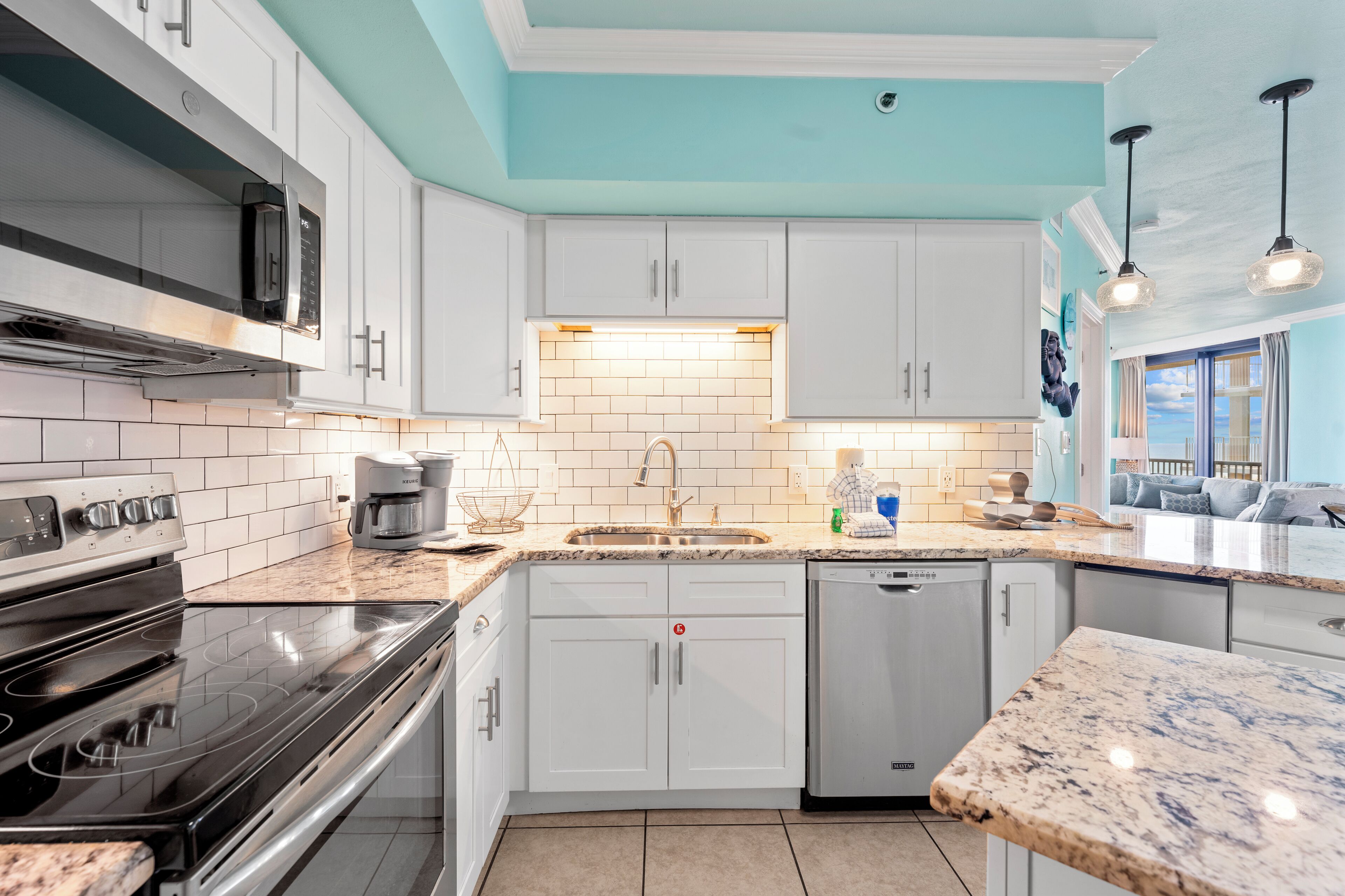 A modern kitchen with white cabinets, a stainless steel stove, and a dishwasher.
