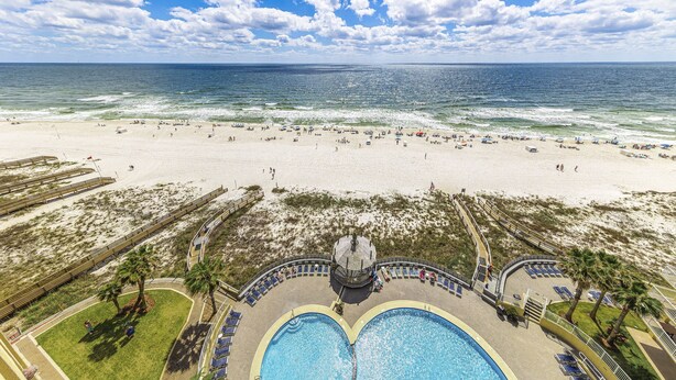 A beach resort with a large pool, beach area, and a view of the ocean. - Summer House Beachfront Condos (Orange Beach)