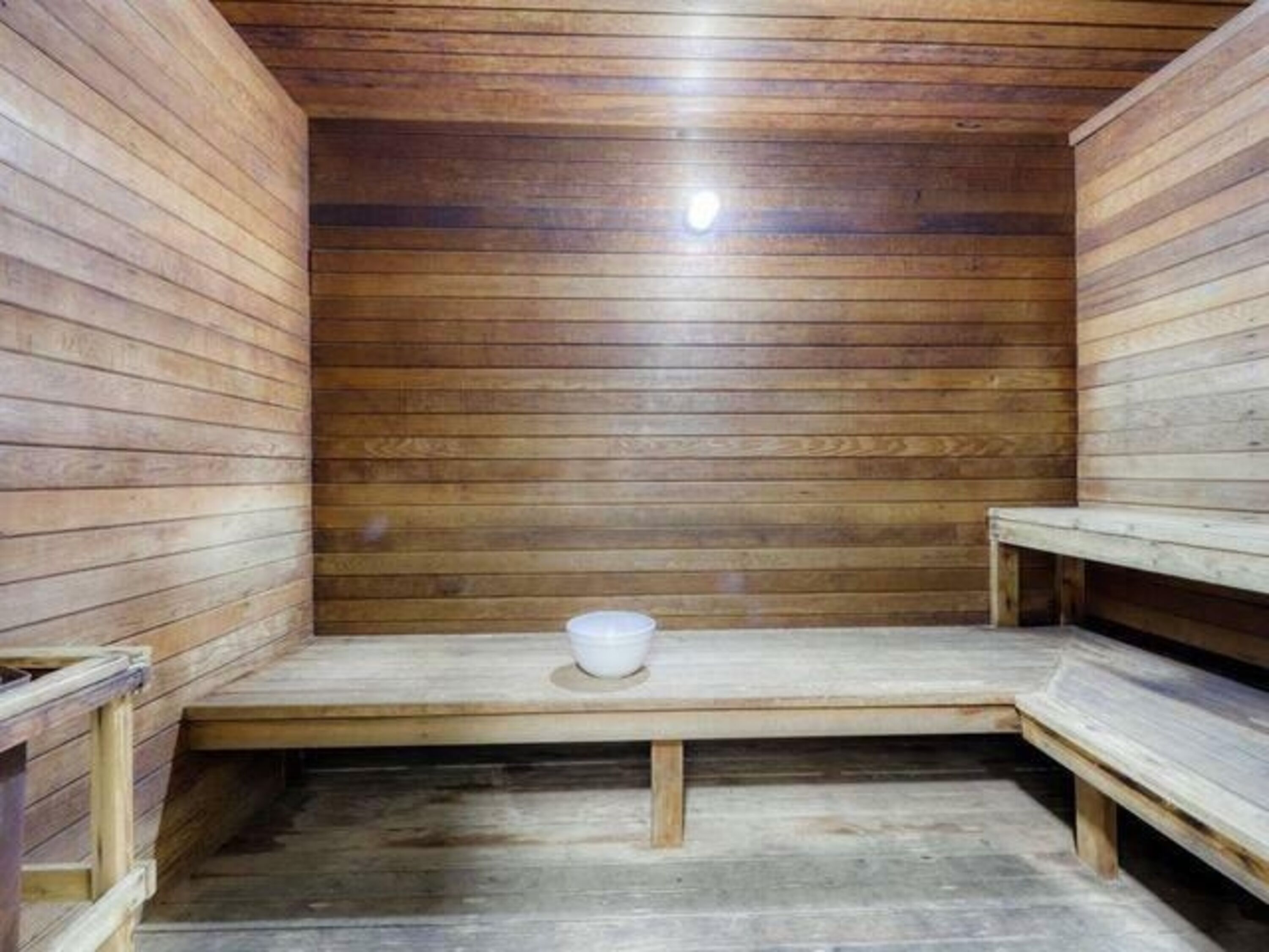 Un sauna en bois avec des bancs et un banc central.