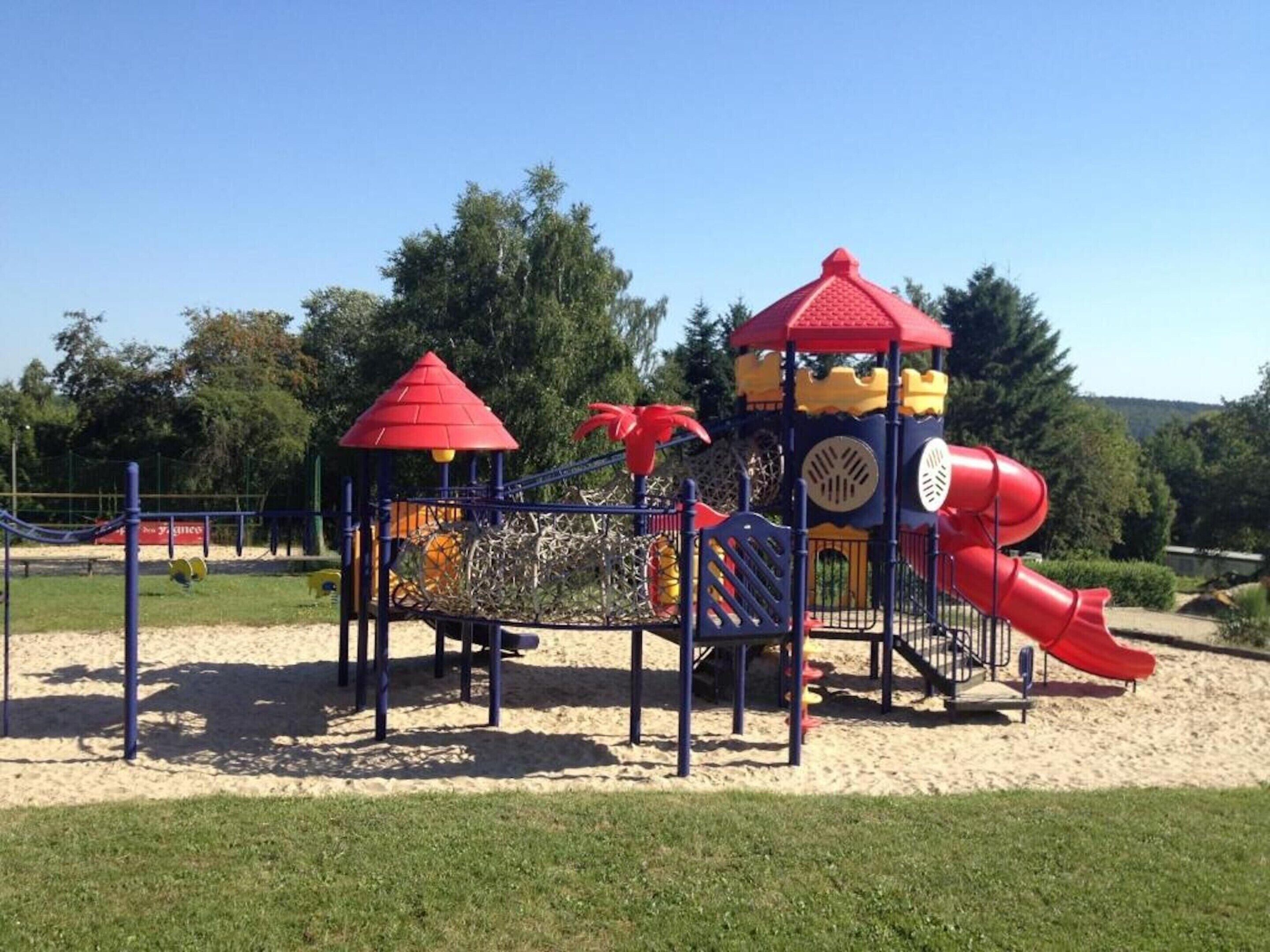 Ein Spielplatz mit Rutsche und Klettergerüsten.