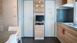 A compact kitchen with a built-in TV, wooden cabinets, and a modern design. - Chalet in Olloy-sur-viroin With Patio (Viroinval)