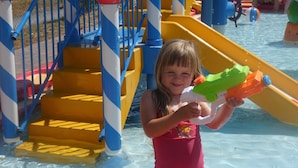 A child in a red swimsuit holding a water gun at a water park. - Chalet in Olloy-sur-viroin With Patio (Viroinval)
