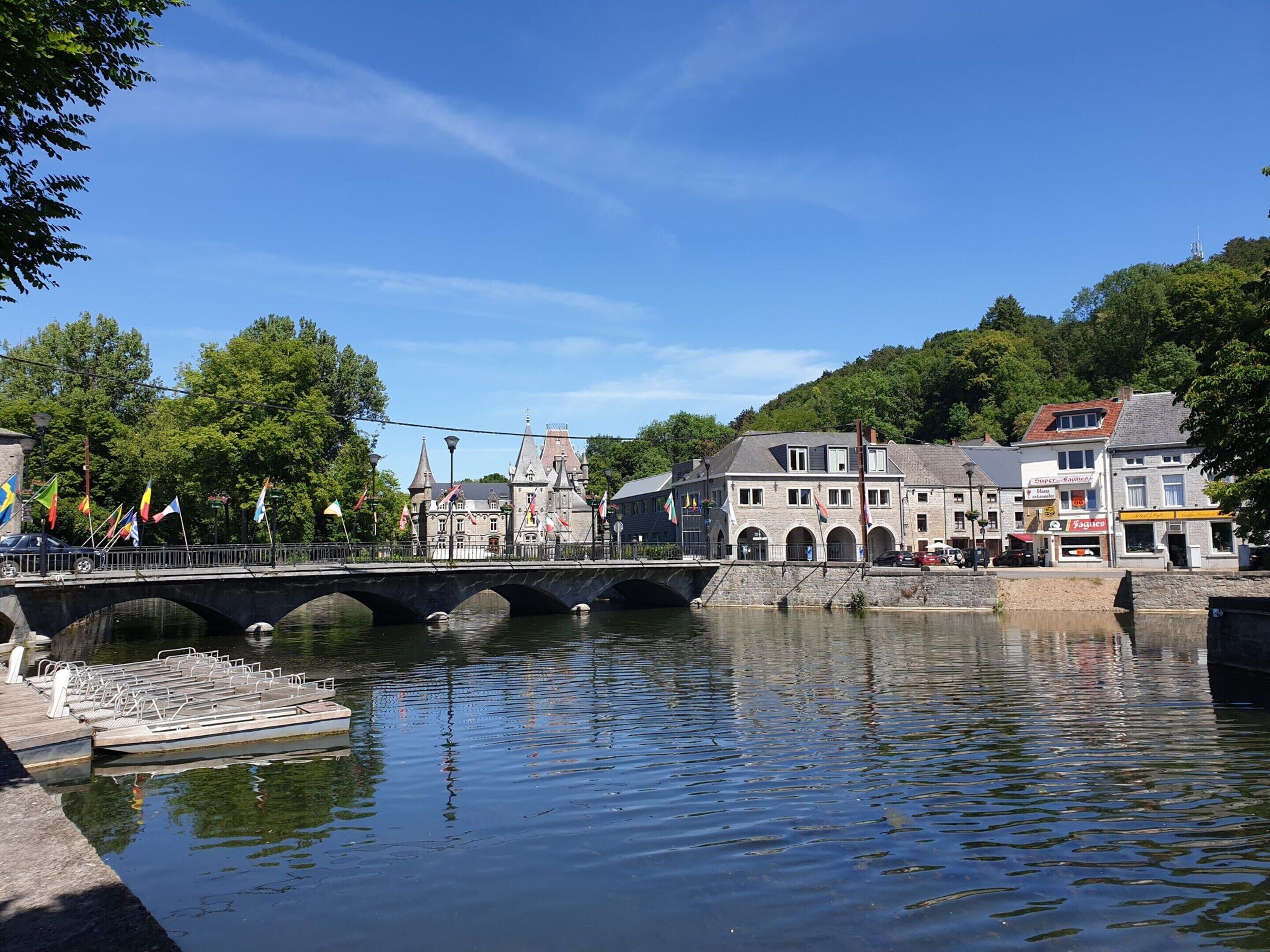 Une ville riveraine dotée d’un pont en pierre, de bâtiments historiques et d’un quai pour bateaux.