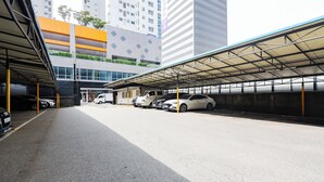 Eine Parkgarage mit mehreren Ebenen, Autos und einem überdachten Gang.