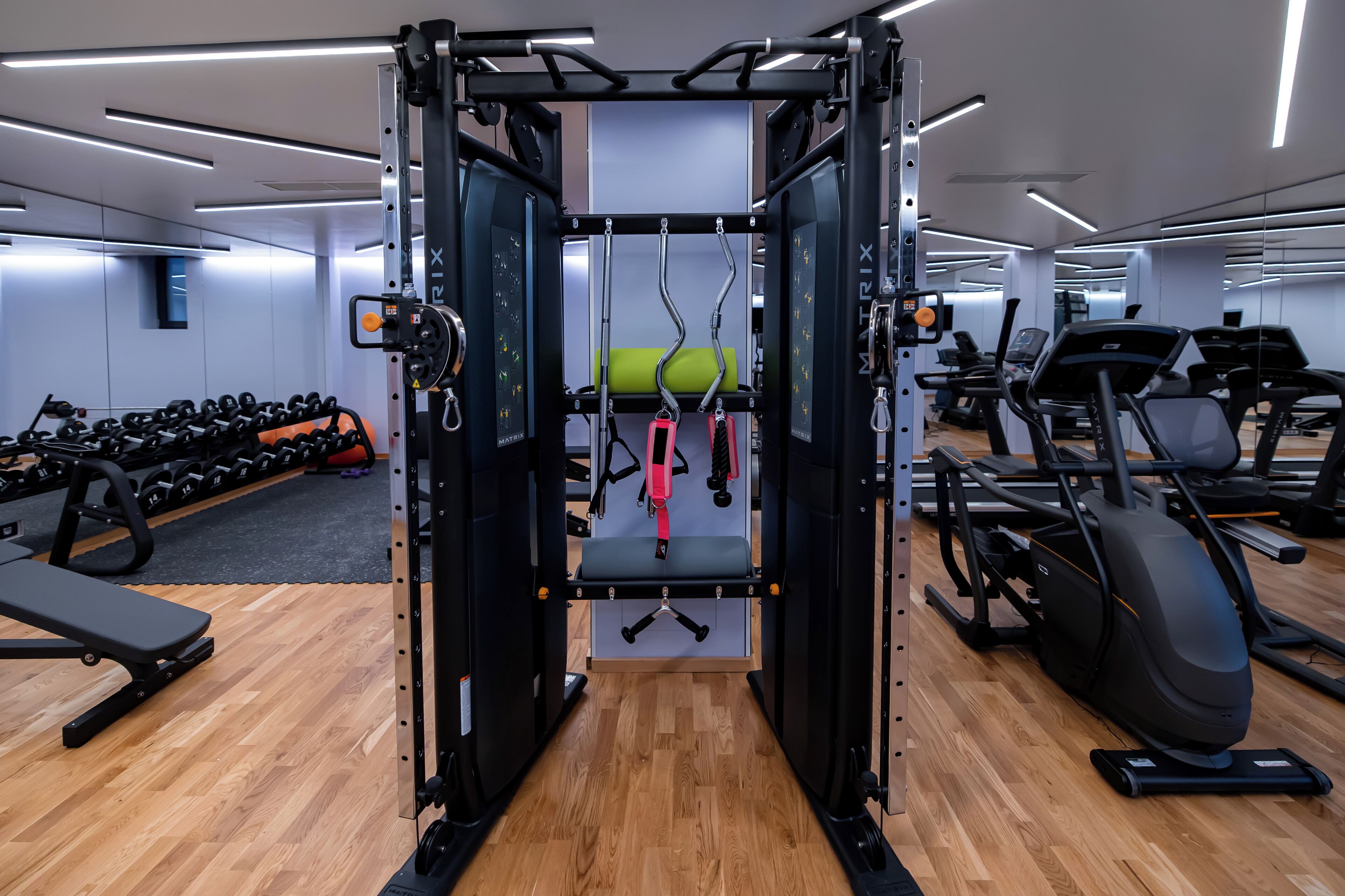 Ein Fitnessraum mit Klimmzugstange, einer Gewichtbank und diversen Trainingsgeräten.