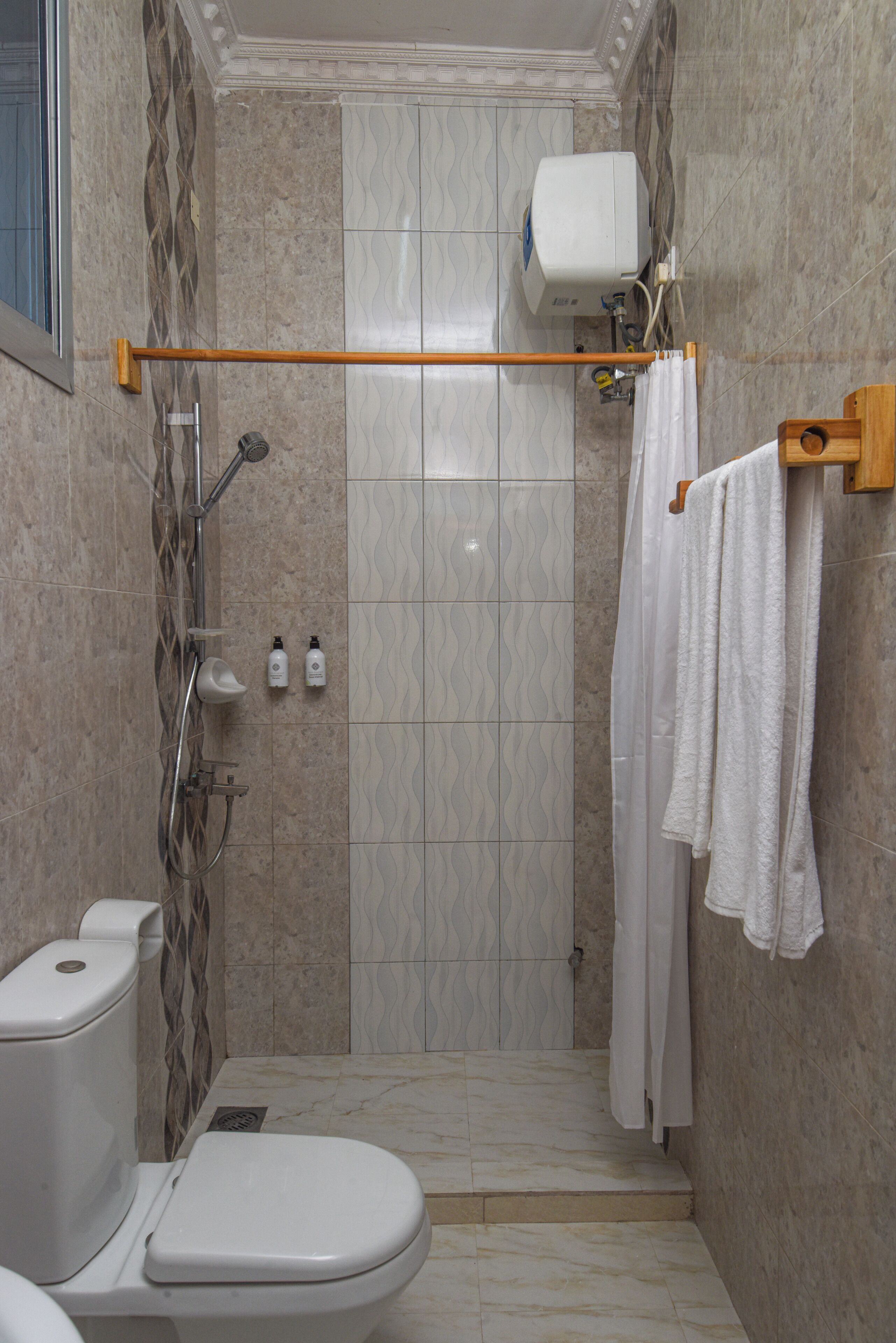 A bathroom with a shower, toilet, and towel rack.