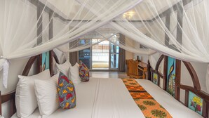 Una habitación con cama, escritorio y vistas al exterior.