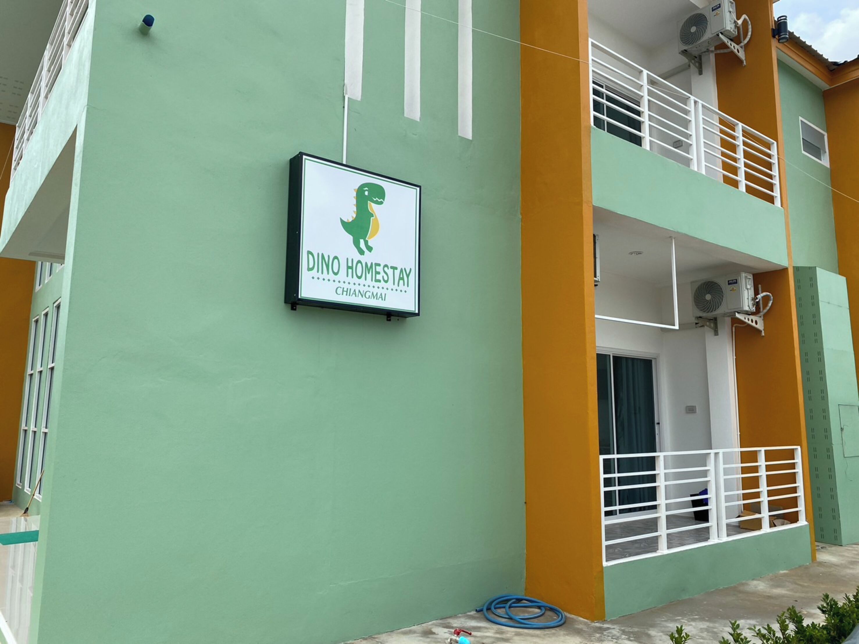 A building with a sign reading "DINO HOMESTAY CHIANGMAI".