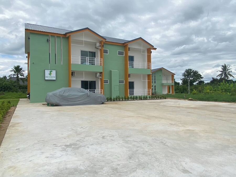 A two-story building with a covered car in the driveway.