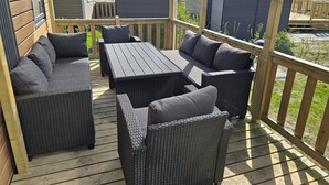 Un patio al aire libre cubierto con muebles de mimbre y una mesa.