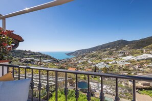 A balcony with a view of a coastal town, a large body of water, and hills in the distance. - Traditional Ligurian House by Wonderful Italy (Sanremo)