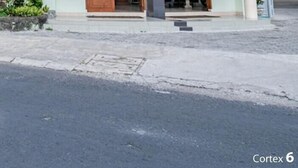 Un bâtiment à deux étages doté d’une façade incurvée, d’une entrée abritée et d’un petit espace extérieur aménagé pour s’asseoir.