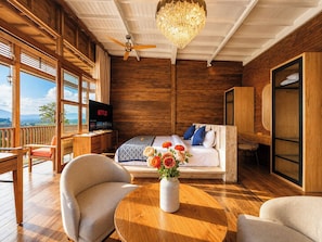 Une chambre avec un lit, une télévision, un bureau en bois et un balcon.