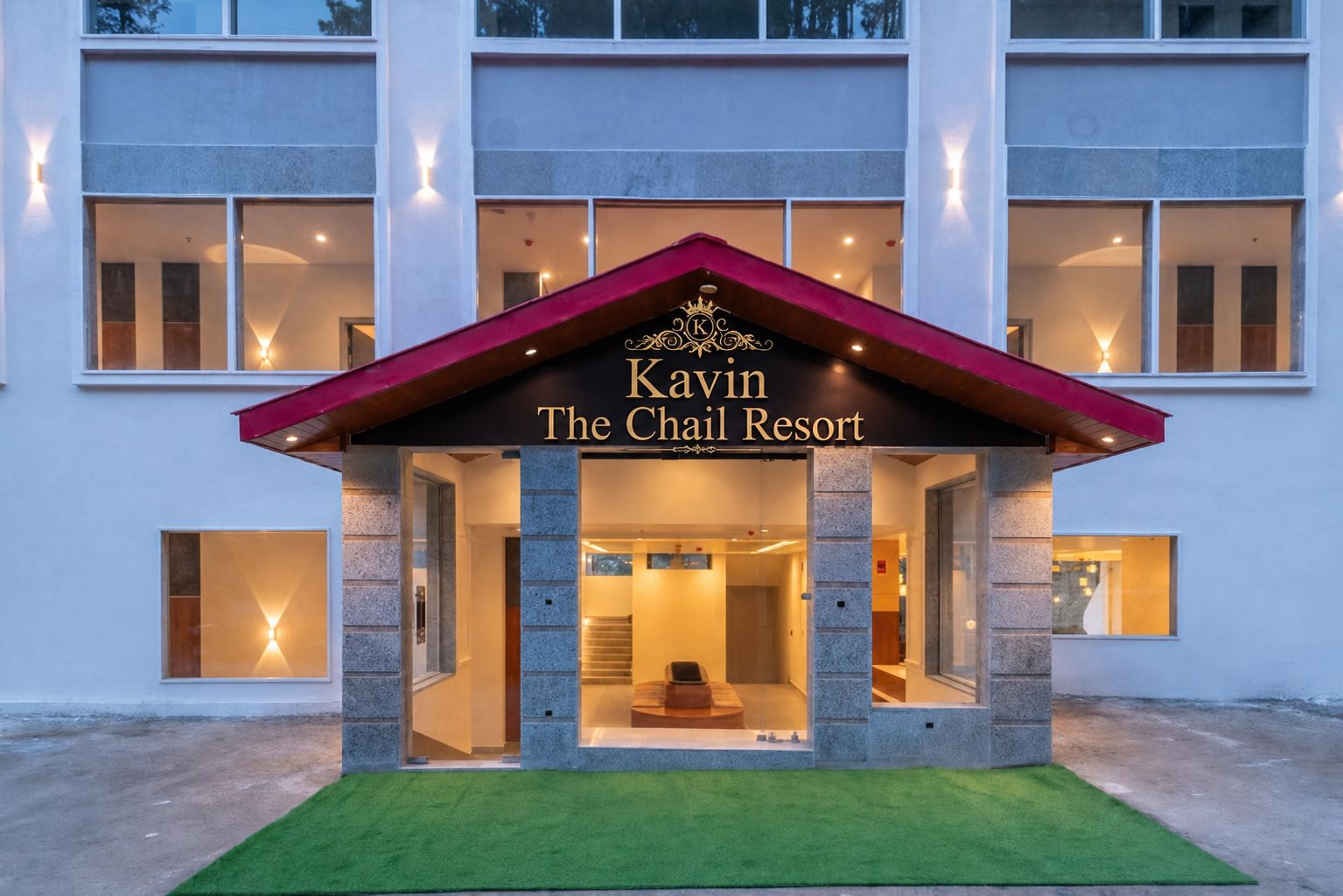 The exterior of the Kevin The Chail Resort with a prominent entrance, stone pillars, and a red roof.