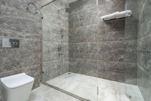A modern shower area with a glass enclosure, a white toilet, and a towel rack. - Kavin The Chail Resort - Serene Valley Views (Kandaghat)
