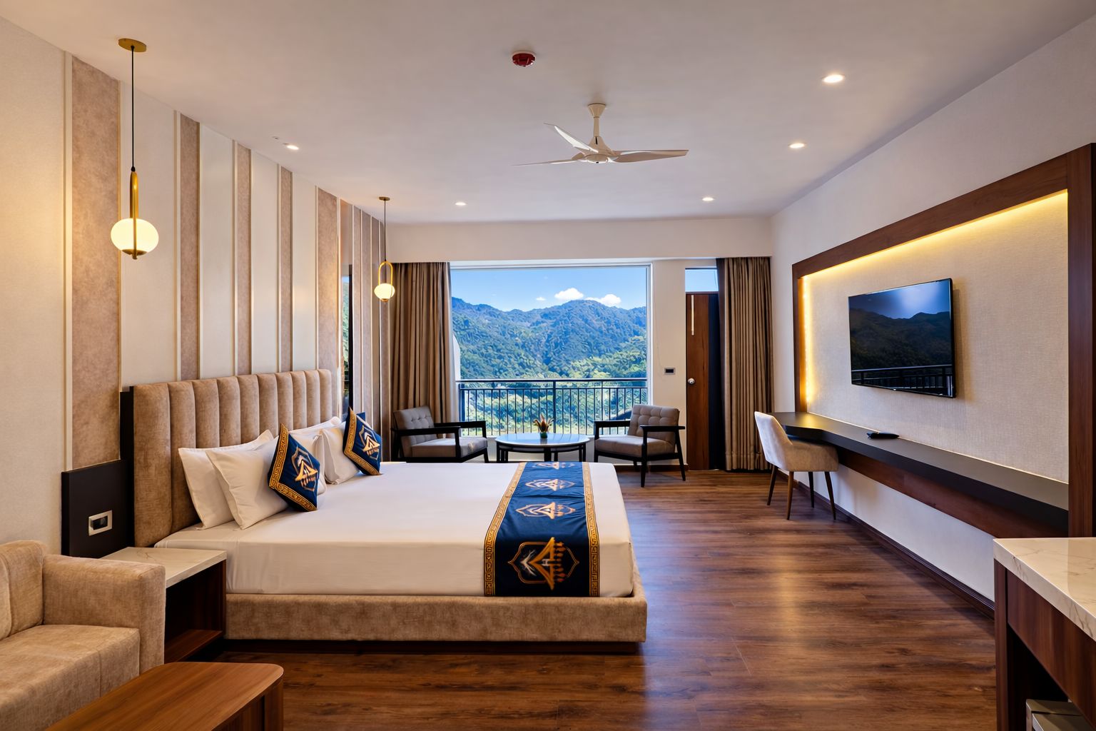 Ein Hotelzimmer mit Bett, Fernseher, Balkon mit Bergblick und Deckenventilator.