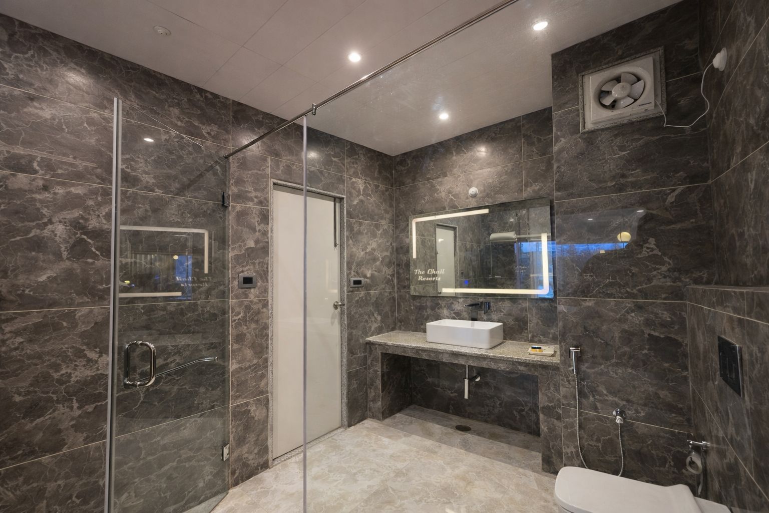 A modern bathroom with a glass-enclosed shower, a white sink, and a large mirror.