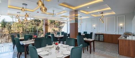 Un restaurante con terraza, sillas tapizadas de verde y una zona de bar.